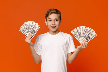 Emotional teenage boy holding fans of dollars