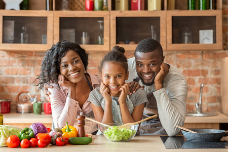 可爱的黑人家庭在厨房一起做健康的晚餐