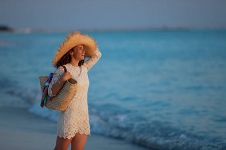 夕阳西下的海边微笑时髦女人