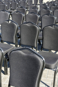 一排排灰色的椅子。街头音乐会会议演讲。