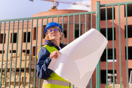 一位女建筑工人在建筑工地检查砖造的房子