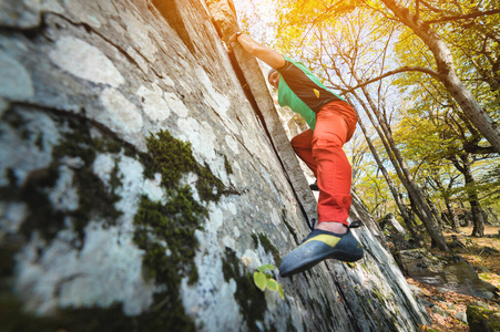 一个自由的老年男性登山者挂在山林中的岩壁上。成熟的体育理念
