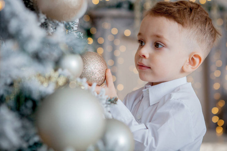 小男孩为圣诞节装饰一棵圣诞树