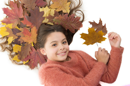 防止头发干裂。孩子们喜欢秋天。女孩可爱的孩子长发披散在白色的背景和落叶。干枫叶发型。秋季季节概念。秋季护发