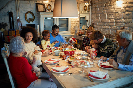 快乐的家人和朋友在家里吃饭庆祝圣诞节