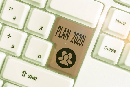 写明2020年计划的笔记。商业照片展示了明年实现目标的详细建议白色pc键盘，白色背景上有便笺。