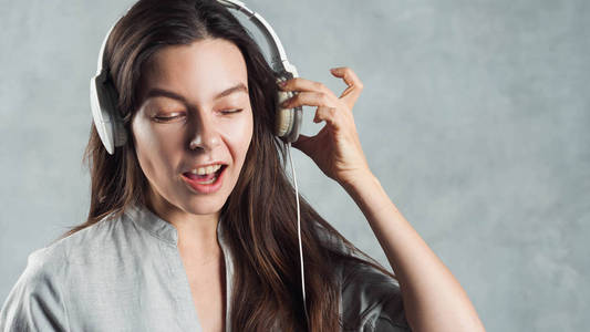 太大的声音，可怕的歌曲和听力问题。年轻的女人把听筒推离耳朵