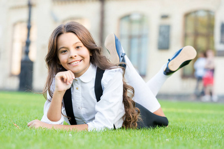 放学休息.可爱的小学生.女孩躺在绿草丛中.孩子在户外放松.