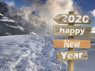 wooden post sign in front of a scenery sunset in snowy mountain 