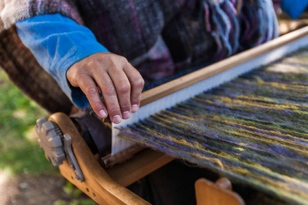 Man is weaving very fancy multi colored wool 