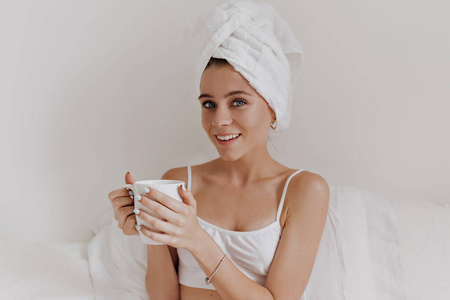 charming beautiful lady with towel around her head sitting in th