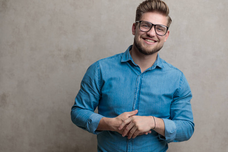 Cheerful casual man laughing and playing with his hands 