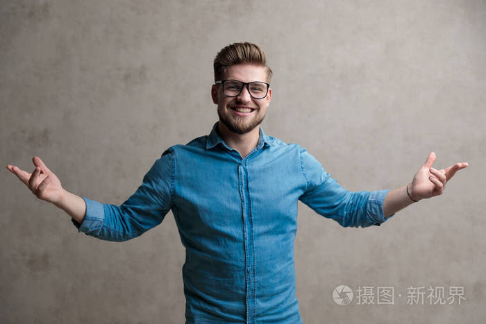 积极的随意的男人张开双臂大笑欢迎