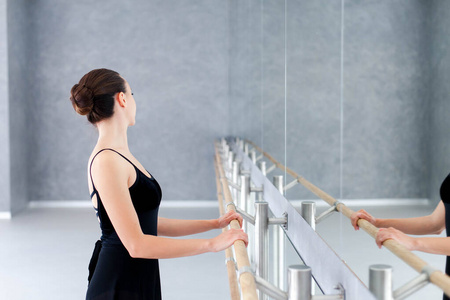 手栏杆芭蕾舞演员正在芭蕾舞教室做练习.舞者把手放在镜子前的栏杆上.