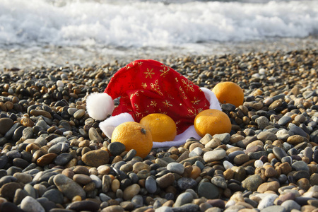 在海上庆祝圣诞节。海滩上圣诞老人的橘子帽