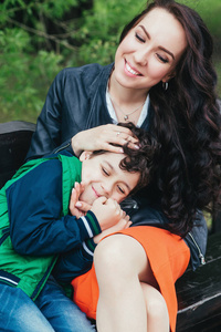妈妈在公园里拥抱她的小儿子。母亲的爱和温柔