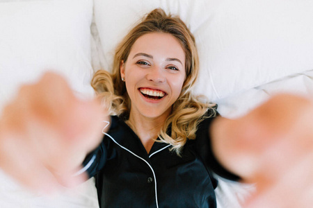 Above frame of happy laughing european woman lying on white pill