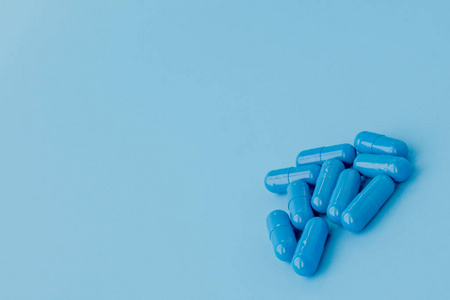 蓝色的胶囊，蓝色背景的药丸。维生素，女性健康的营养补充剂