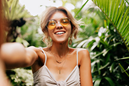 Young caucasian pretty woman wearing yellow round glasses making