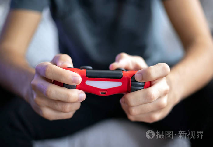 年轻人玩游戏机前视图