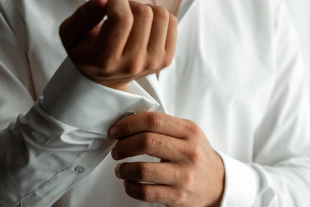 商人的手，特写，衬衫上的纽扣袖子。