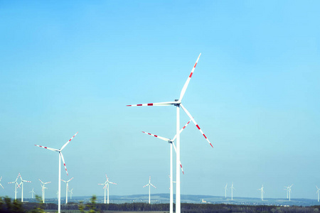 风力涡轮机。可持续发展，可再生能源能源。风车在电力生产方面，白色风力涡轮机在蓝天上发电。