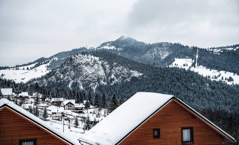冬天的房子在冬天的山上，白色的云杉。白雪皑皑的森林山坡上令人惊叹的景色。圣诞假期概念。欧洲喀尔巴阡山脉