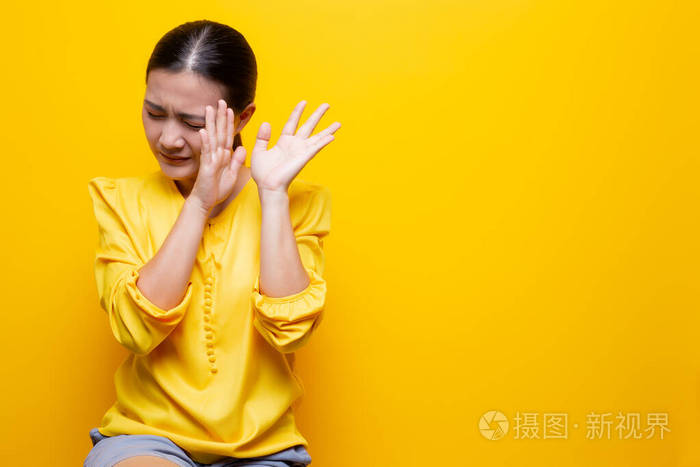 女人站在黄色背景上感到害怕