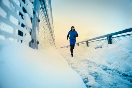 Runner sprints fast as he runs outside on a grey day 