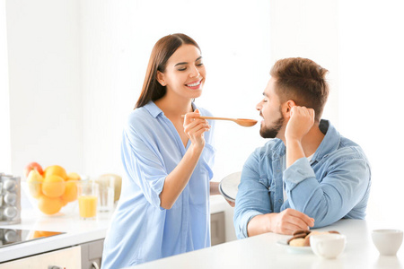 漂亮的年轻夫妇在家里的厨房里一起做饭