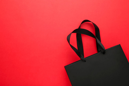 红色背景的黑色购物袋。