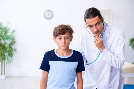 年轻男医生在诊所检查男孩