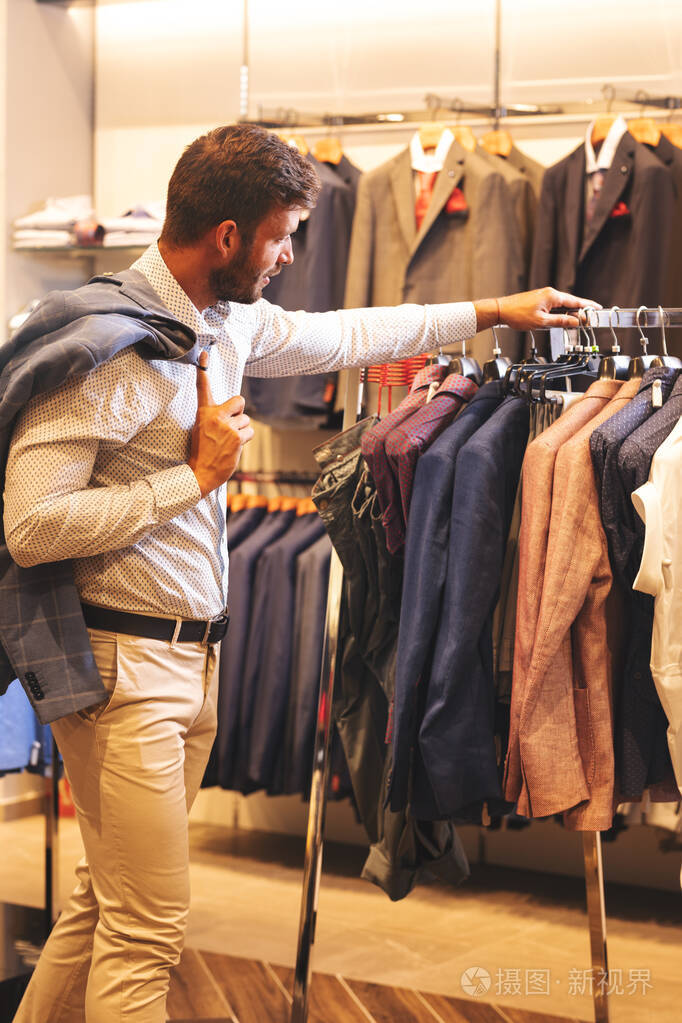 Elegant young man shopping in menswear