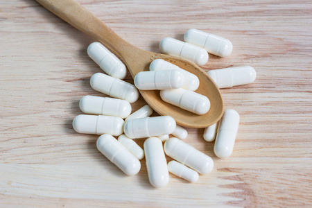 close up the capsules on wood table  