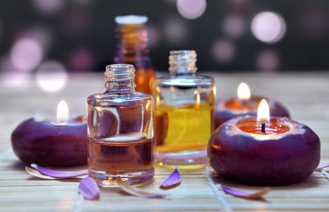 bottles of oil  and candle on blur lights background 