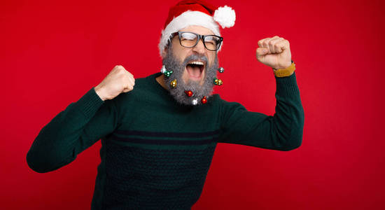 戴着装饰胡须和圣诞老人帽的男人在庆祝