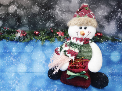 圣诞雪人玩具与冷杉树枝装饰和雪