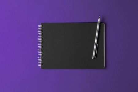紫罗兰色背景的黑色笔记本