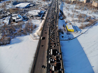 在寒冷晴朗的冬天，列宁格勒斯基高速公路的全景鸟瞰图。美丽的城市景观河流覆盖着冰层。上的汽车舰桥。无人机射击。