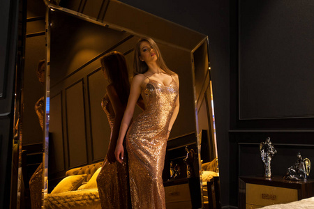 Glamorous interior golden mirror. Fashion Beautiful young woman 