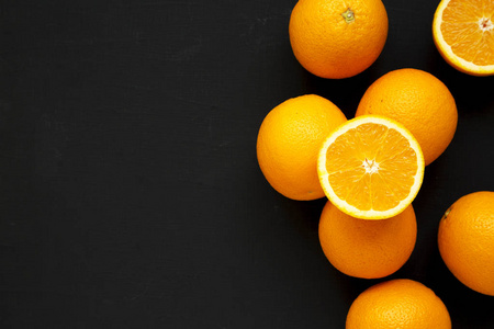 Ripe organic oranges on a black background, top view. Flat lay, 