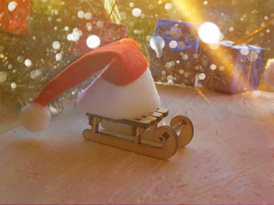圣诞贺卡构图。木制雪橇，雪橇上有圣诞老人红帽子。圣诞节新年十二月庆祝时间概念。