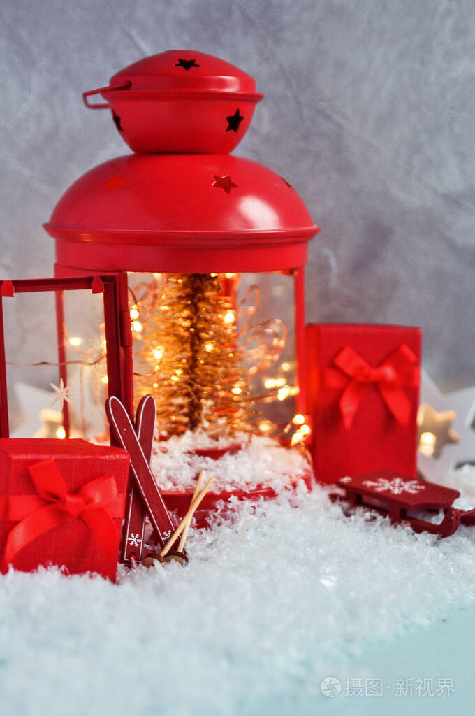 圣诞仙女组成的红灯笼内有圣诞树和彩灯，装饰滑雪板，带装饰的雪橇，灰色背景雪地上的礼物。