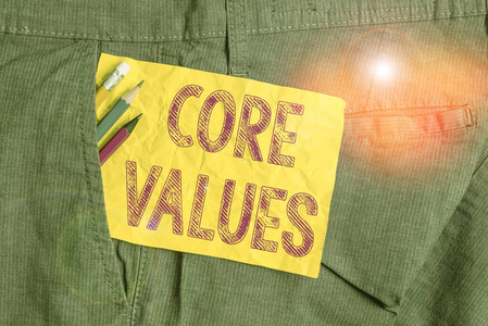 文字写作的核心价值观。商业概念用于演示或组织的基本信念或原则，书写设备和黄色便笺放在工作裤口袋里。