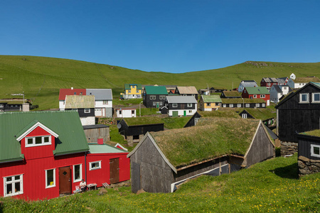 Beautiful village of Mykines with colorful houses with grass on 