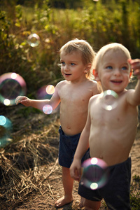 可爱的双胞胎兄弟看着飞舞的泡泡