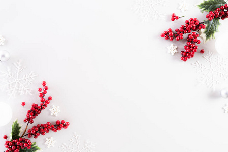 圣诞背景概念。白色背景上雪花和红色浆果的圣诞球俯视图。