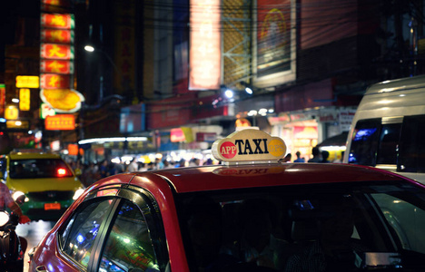 Taxi sign with defocused lights blur in Chinatown in Bangkok at 