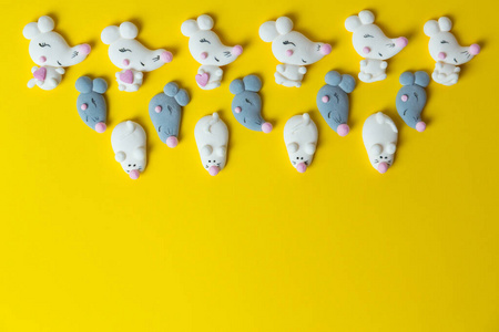 糖果。棉花糖框架形状为白色和灰色的老鼠或老鼠，背景为黄色，俯视图，复制空间。2020年新年背景和纹理