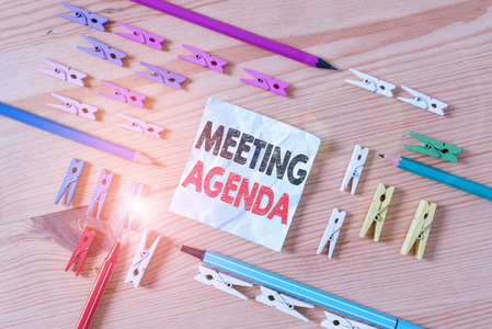 文字写作会议议程。商务概念项目，与会者希望在会议上完成彩色衣夹纸空提醒木地板背景办公室。